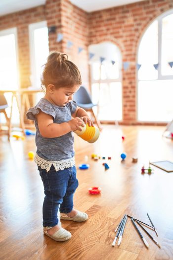 Kind spielt mit einem Becher